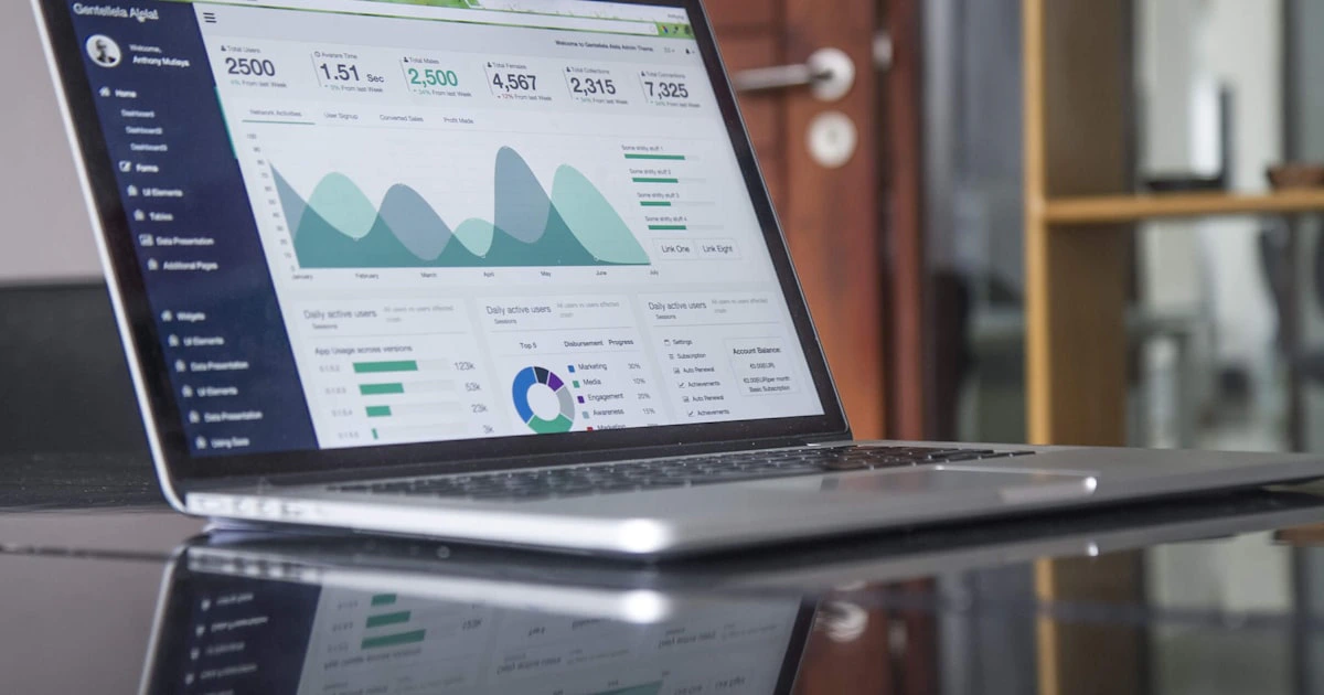 Laptop showing website traffic analytics with graphs of visitor and conversion trends